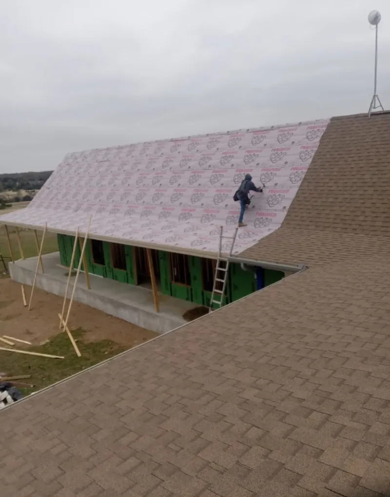 Worker preparing underlayment for a metal roof installation in North Platte